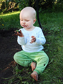 Pihalla leikkivä poika, joka ihmettelee mutaa. Kuva Kimmo Saarinen.